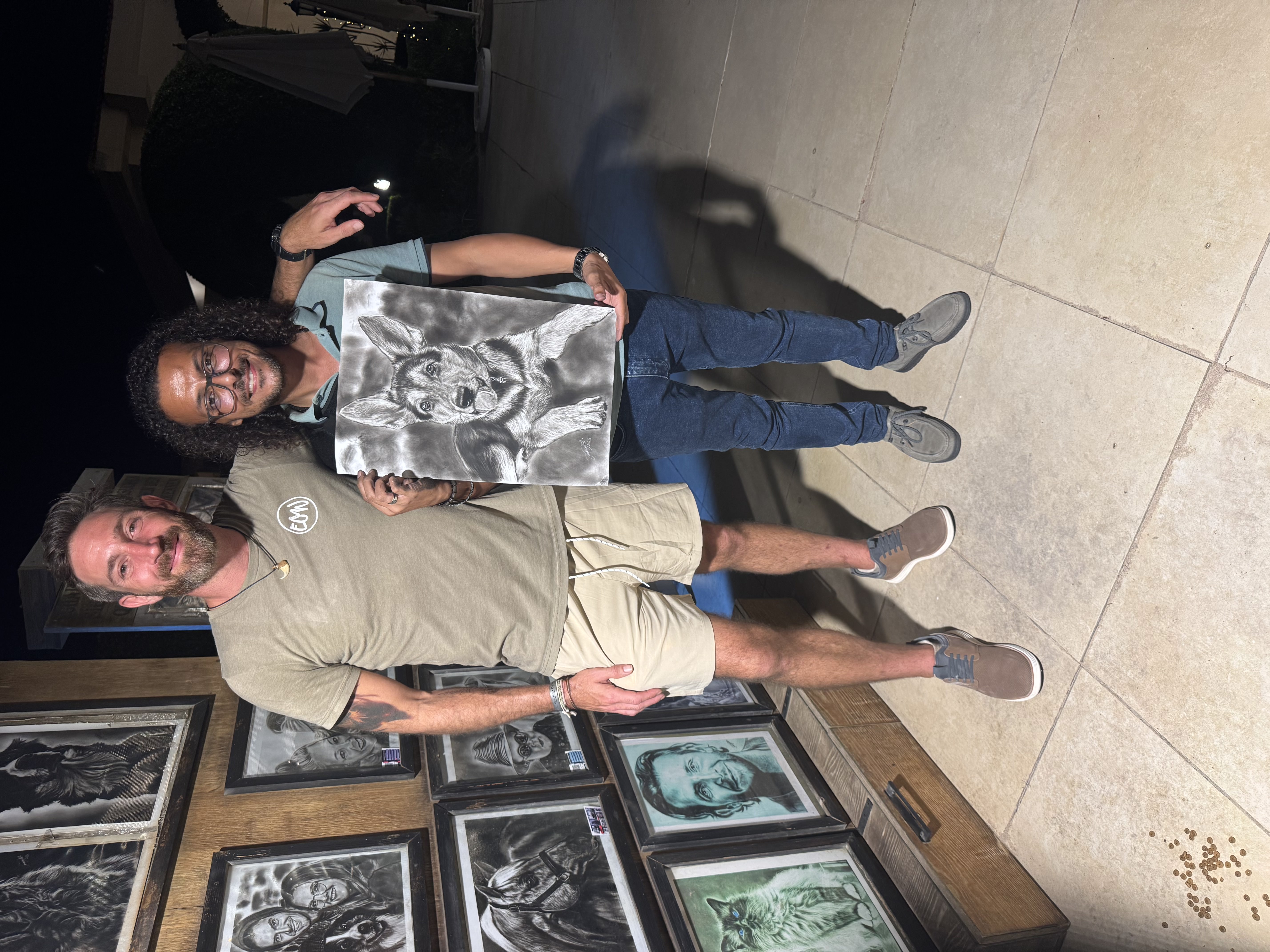 Wasseem Tayssir at his seaside studio holding a hand-drawn portrait